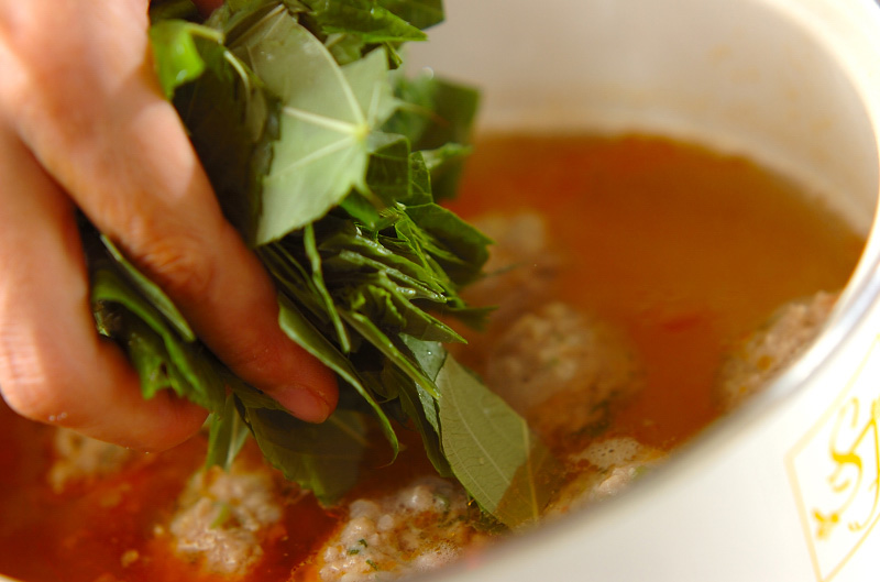 鍋のスープが煮たったら、肉団子を手で丸めて入れる。